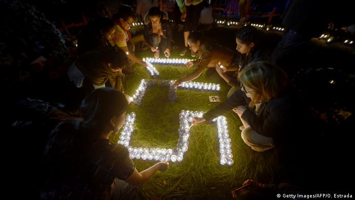Women kneeling in front of lit candles spelling out 571 Guatemala(Getty Images/AFP/O. Estrada)